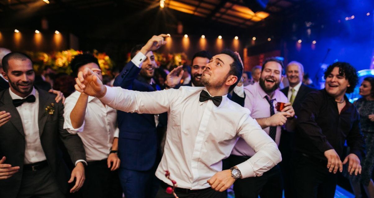 Group of people dance and laugh at a wedding