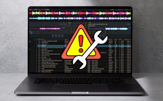 A laptop displaying Mixxx DJ software against a concrete background. There's a yellow, orange, and red warning sign indicating a troubleshooting issue.